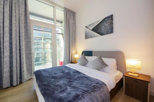 ein Schlafzimmer mit einem Bett und einem großen Fenster in der Unterkunft Silk Valley - Cozy 1bhk With Pool And Gym in Abu Dhabi
