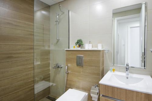 uma casa de banho com um chuveiro, um lavatório e um WC. em Silk Valley - Furnished 1bhk With Pool And Gym em Abu Dhabi