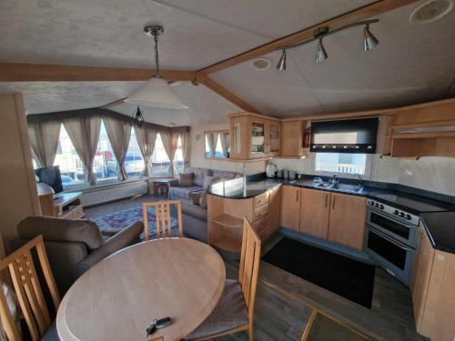 a kitchen with a table and a living room at Jade's Haven - Pet friendly, Ingoldmells in Ingoldmells