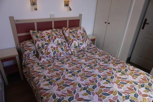 - un lit avec une couette en fleurs dans une chambre dans l'établissement the elegant cap esterel, à Saint-Raphaël