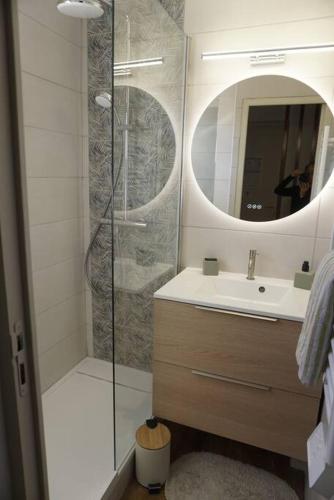 une salle de bain avec une douche, un lavabo et un miroir dans l'établissement the elegant cap esterel, à Saint-Raphaël