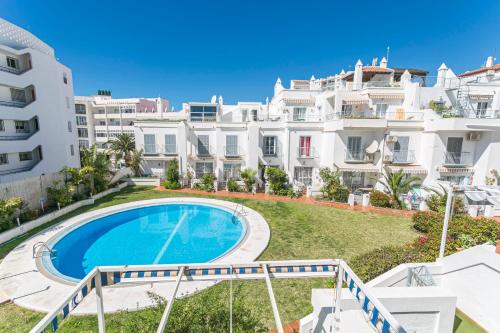un appartamento con piscina di fronte a un edificio di Canovas Nerja - Casa adosada con piscina Los Huertos 3 a Nerja