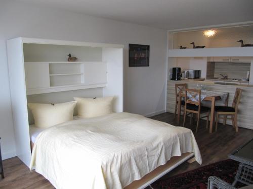 Cet appartement comprend une chambre avec un lit et une table ainsi qu'une cuisine. dans l'établissement Hanseatenhaus Appartement 67, à Westerland