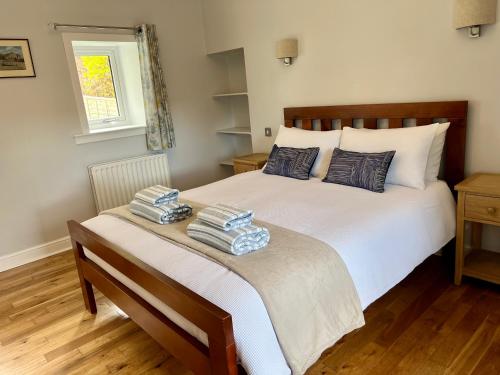 een slaapkamer met een bed met twee handdoeken erop bij Owl Cottage - Dog Friendly in Invergarry