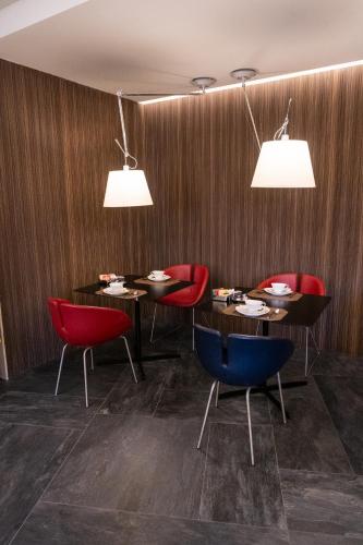 ein Restaurant mit vier Tischen und roten Stühlen in der Unterkunft Stendhal Luxury Suites in Rom