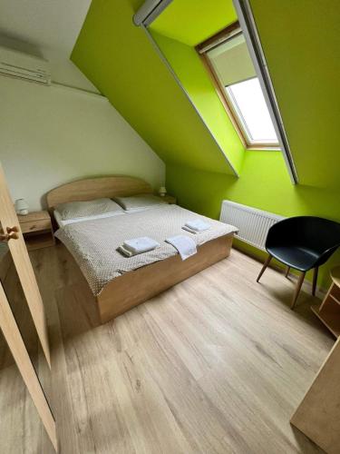 una camera da letto con un letto con pareti verdi e una finestra di Penzion Villa Rozárka a Staré Město