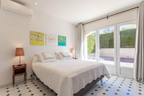um quarto com uma cama e uma grande janela em Villa de prestige avec piscine em Saint-Raphaël