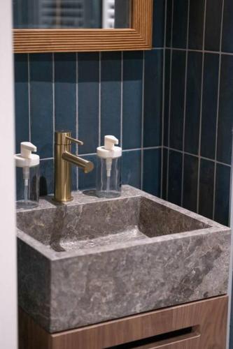 a marble sink in a bathroom with a mirror at L'étoile d'or - Palace in Vichy