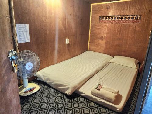 a small room with a bed and a fan at TiTi House in Dồng Văn
