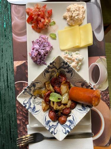 a plate of food with a carrot and other foods at Wellness Hotel Várfal in Pécs