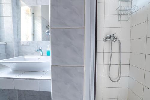 a white bathroom with a sink and a shower at Trzy Kafki Private Rooms in Kraków