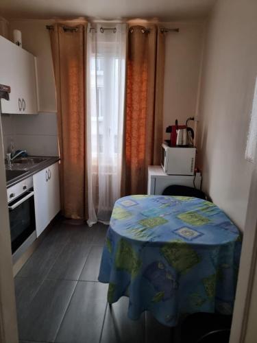 eine kleine Küche mit einem Tisch und einer Mikrowelle in der Unterkunft Rue de l'Indiennerie 3 in Genf