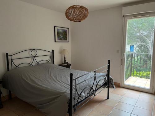 a bedroom with a bed and a large window at esterel-plage in Saint-Raphaël