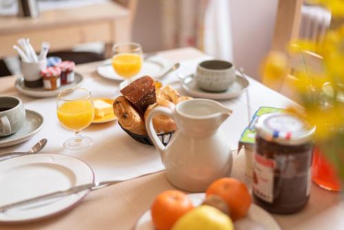 a table with a breakfast of bread and orange juice at Hôtel Restaurant Le Relays du Chasteau - Logis Hôtel in Brousse-le-Château