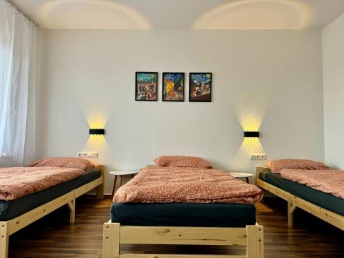 two beds in a room with two lamps on the wall at Main Weindorf Unterkunft in Sulzfeld am Main