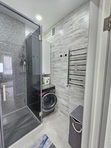 a bathroom with a shower with a glass door at 3 room Gagarin Park Residential Complex near MEGA Shopping Mall in Almaty