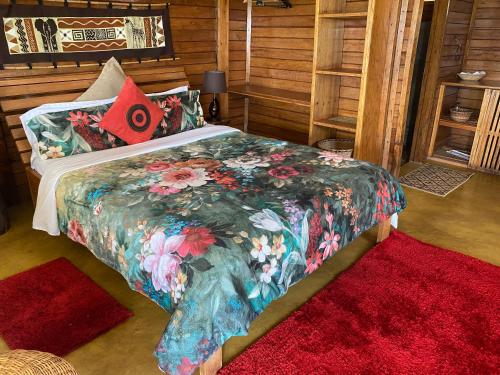 1 Schlafzimmer mit einem Bett mit Blumendecke in der Unterkunft Home On The Nile Ernest Hemingway Suite in Jinja