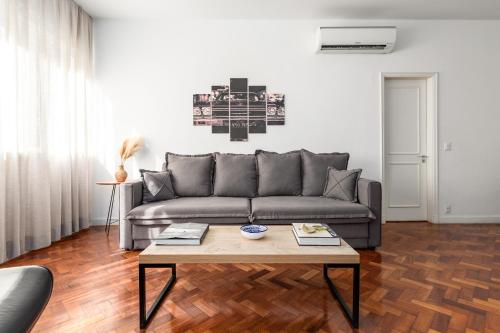 uma sala de estar com um sofá e uma mesa de centro em Unhotel - Charmoso Apartamento Temporada com 3 quartos em Copacabana no Rio de Janeiro