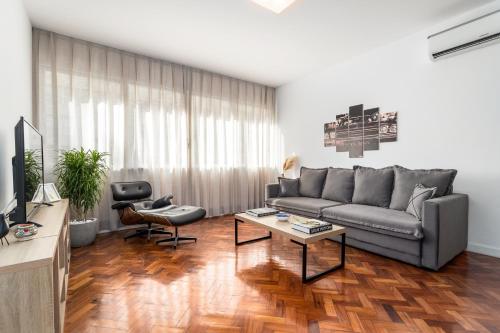 uma sala de estar com um sofá e uma mesa em Unhotel - Charmoso Apartamento Temporada com 3 quartos em Copacabana no Rio de Janeiro