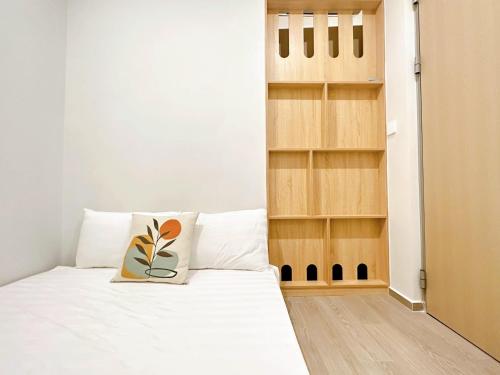 a bedroom with a white bed with a pillow on it at The Sóng Hotel & Apartment Vũng Tàu in Vung Tau