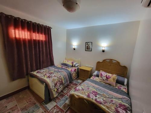a bedroom with two beds and a window at Pyramids Porto El Sokhna Familis Only in Ain Sokhna