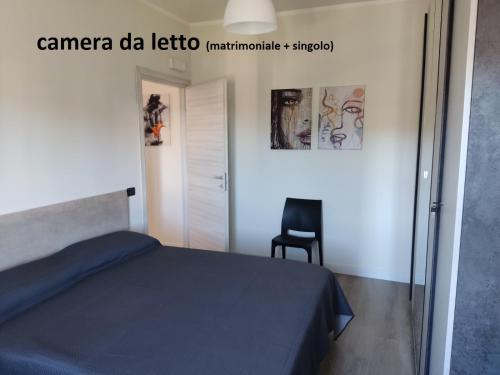 1 dormitorio con 1 cama y 1 silla negra en Sunrise Apartment Marina Beach, en Marina di Gioiosa Ionica