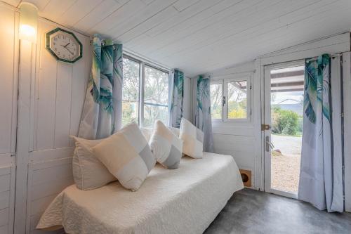 - une chambre dotée d'un lit avec une horloge murale dans l'établissement Joli Bungalow, à Roquebrune-sur Argens