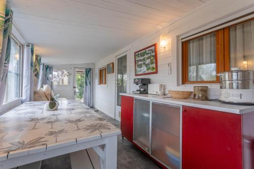 une cuisine avec des armoires rouges et un comptoir dans l'établissement Joli Bungalow, à Roquebrune-sur Argens