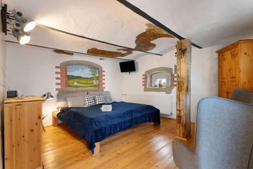 a bedroom with a bed with a blue comforter at Stub'n Herbert in Waischenfeld