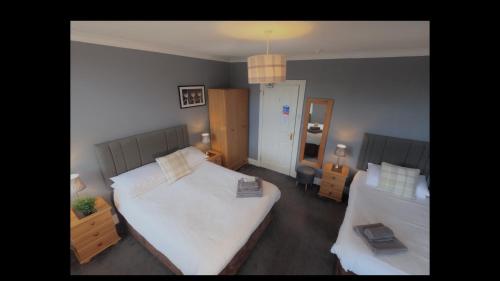 a living room with two beds and a room with two tables at Brook House ― Free on-site car park in Windermere