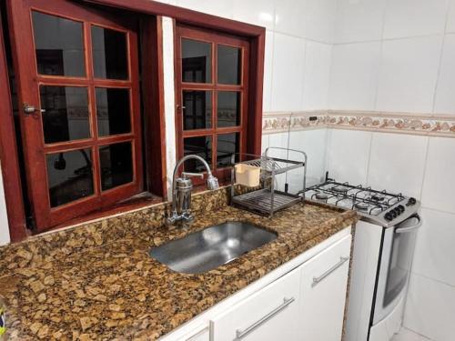 cocina con fregadero y fogones en Apartamento amplo cabo frio en Cabo Frío