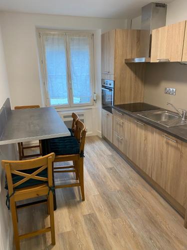 une cuisine avec des armoires en bois et une table et des chaises dans l'établissement La Petite Auberge de Strasbourg, à Strasbourg