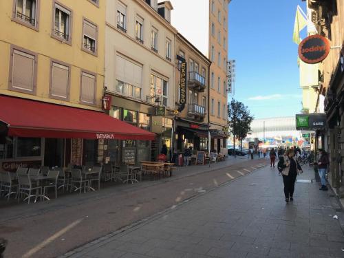 una mujer caminando por una calle de la ciudad con edificios en La Petite Auberge de Strasbourg en Estrasburgo