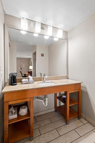 a bathroom with a sink and a large mirror at Travelodge by Wyndham Pueblo in Pueblo