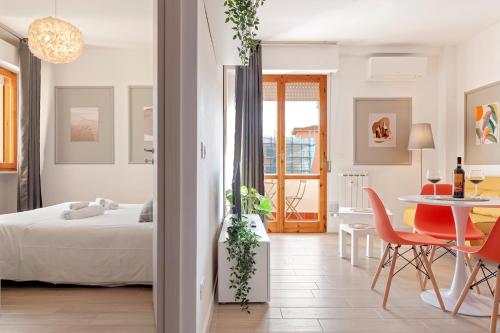 1 dormitorio con 1 cama, mesa y sillas en Homiday- New Apt- Free Parking- Aeroporto - Ospedale en Pisa