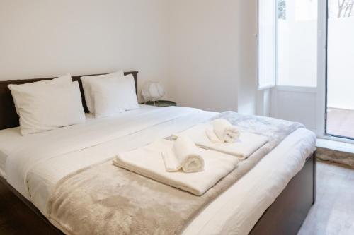 Una cama blanca grande con toallas. en Diogo's Alcântara Apartment II by Mycelia, en Lisboa