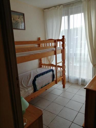 une chambre avec deux lits superposés et une fenêtre dans l'établissement appartement port camargue 6 personnes le cabestan, au Grau-du-Roi