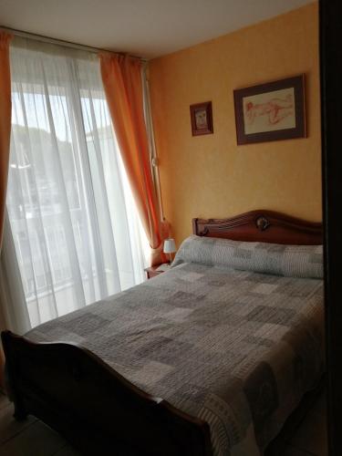 une chambre avec un lit et une grande fenêtre dans l'établissement appartement port camargue 6 personnes le cabestan, au Grau-du-Roi