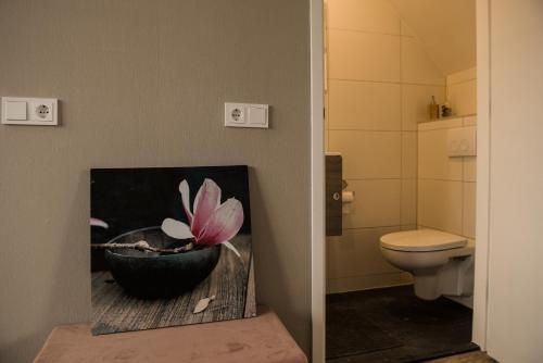 a bathroom with a painting of a flower in a pot at Eetcafé Punt in Roelofarendsveen