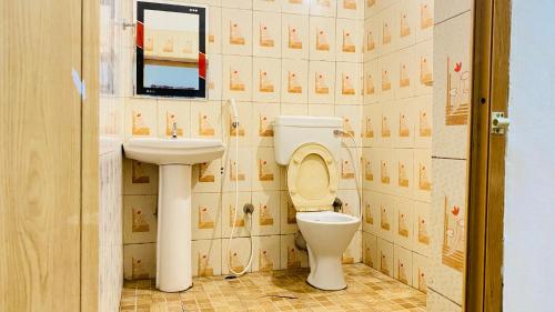 een badkamer met een toilet en een wastafel bij Misty Green Coorg in Madikeri