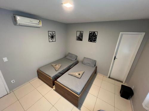 a room with two beds and a air conditioner at DLUX Hotel in Campos dos Goytacazes