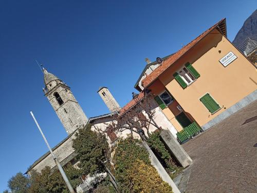 a church with a clock tower and a building at Appartamento Riviera in Cremia