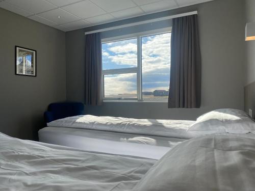 a bedroom with two beds and a window at Vagnsstadir Guesthouse in Borgarhöfn