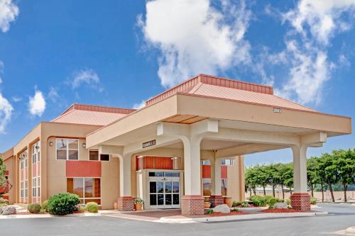 a large office building with a building at Ramada by Wyndham West Memphis in West Memphis
