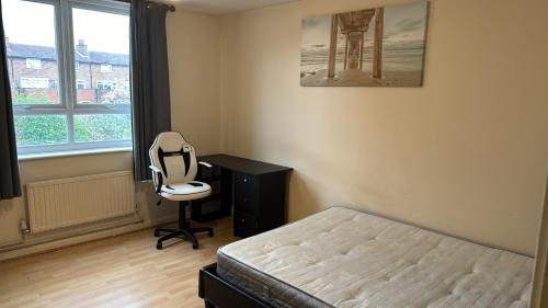 1 dormitorio con cama, escritorio y silla en Eynsford down, en Londres