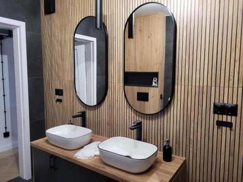 a bathroom with two sinks and two mirrors on the wall at AXO-HOSTELS in Stalowa Wola