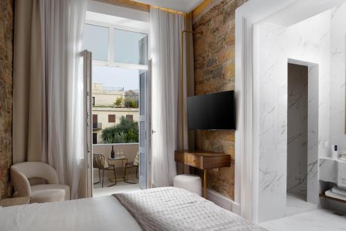 a bedroom with a king sized bed and a view of a patio at La Divina in Athens