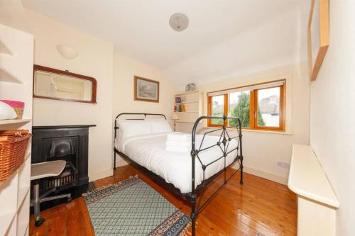 een kleine slaapkamer met een bed en een raam bij Serene 2BD Home wGarden Newtown Little Dublin! in Rathgar