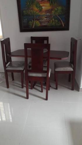a dining room table and two chairs and a table at Maison de vacances in Santo Domingo