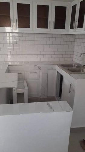 an unfinished kitchen with white cabinets and a sink at Maison de vacances in Santo Domingo